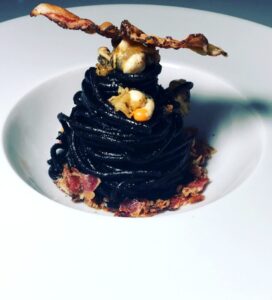 Spaghetti al nero, polpa di canestrello e guanciale croccante