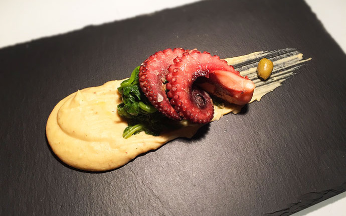 Polpo croccante cotto a bassa temperatura su crema di fave e cime di rapa