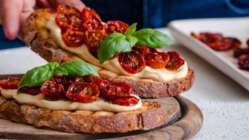 Ricetta del giorno bruschette con crema di ceci, pomodorini arrosto e basilico