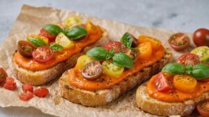 Bruschette con crema di peperoni, pomodorini e basilico
