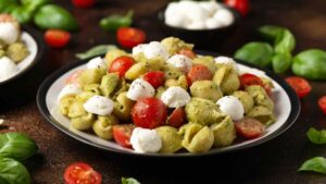 Pasta fredda tricolore con pesto leggero, mozzarella e pomodorini